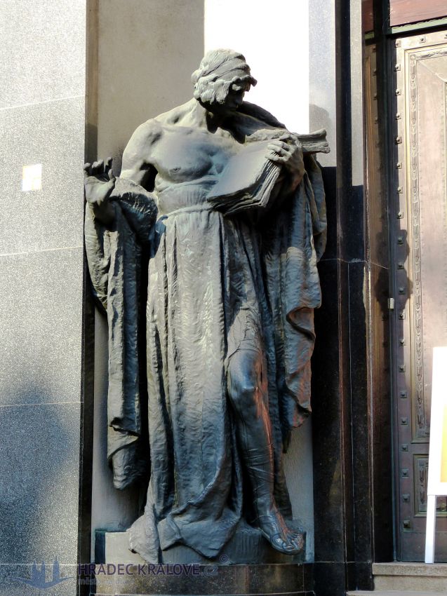 U vstupního portálu je socha znázorňující obchod 
